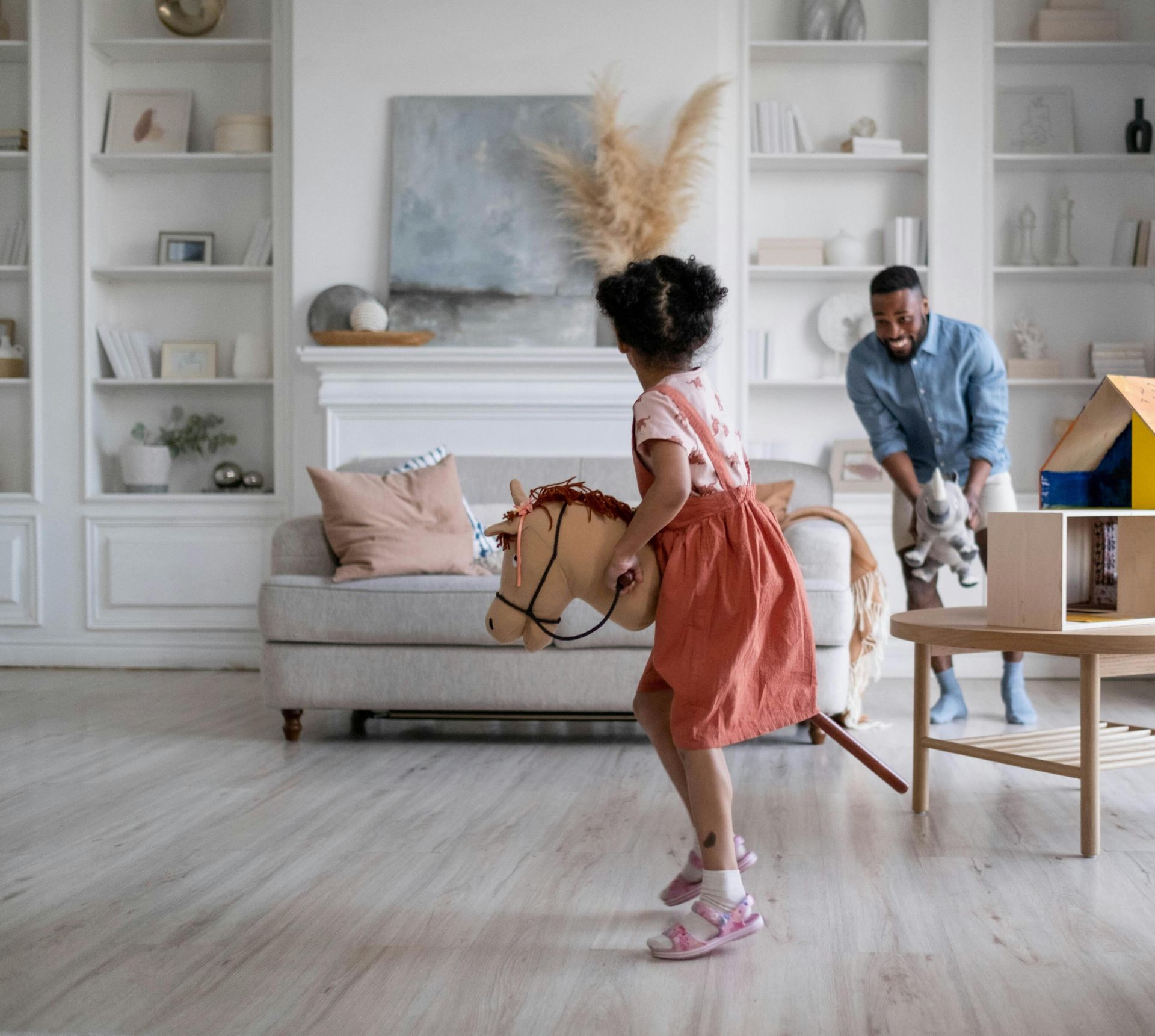 Father and daughter enjoying playful moment in stylish living room setting, highlighting family bonding.